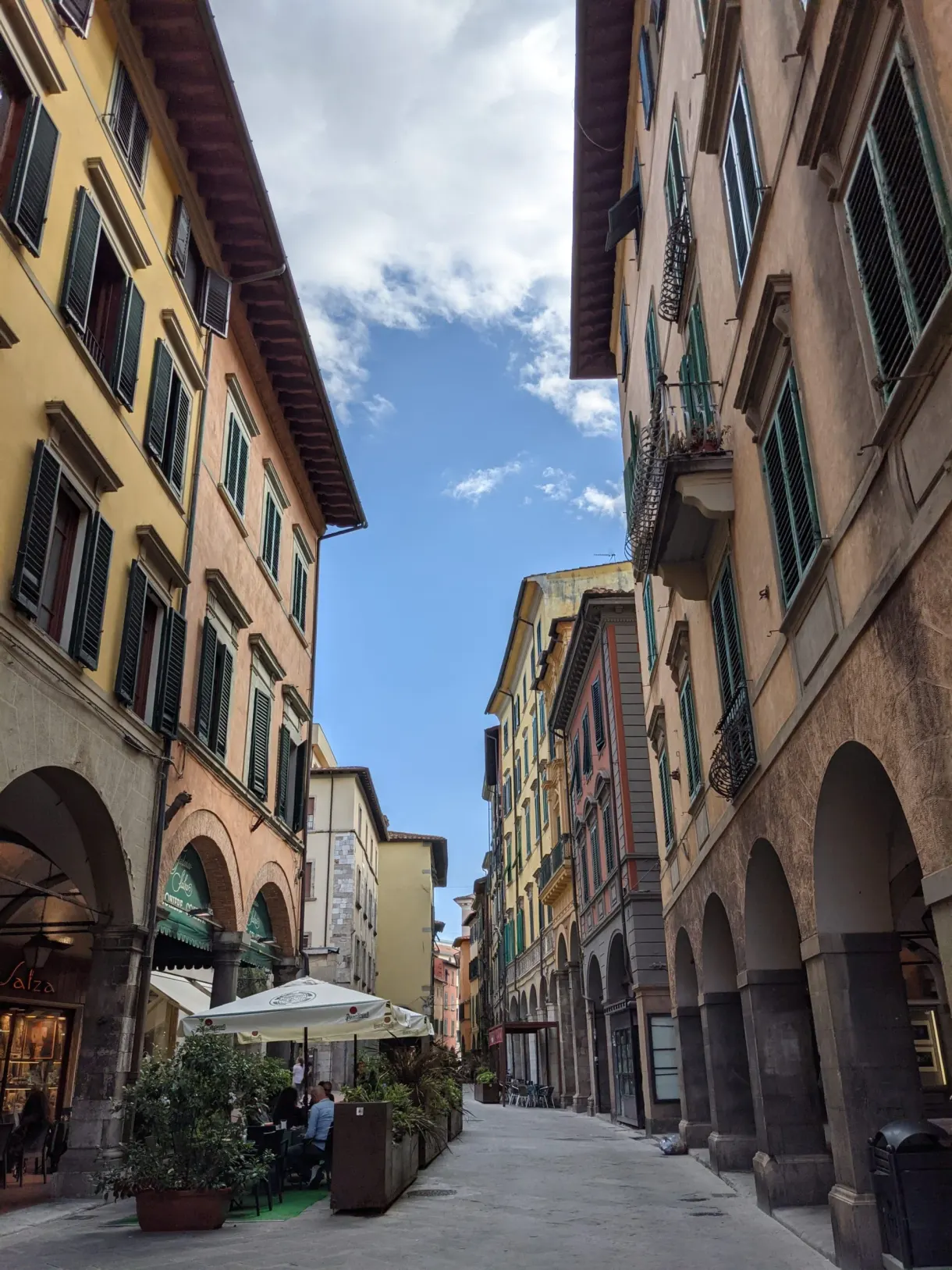 Shopping street beneath the arcades with its cafe terraces