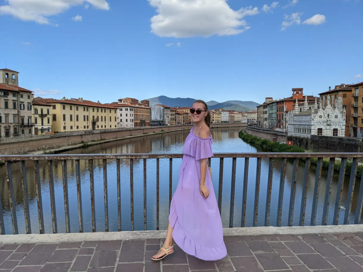Woman in a purple dress on the bridge, the Arno stretching away