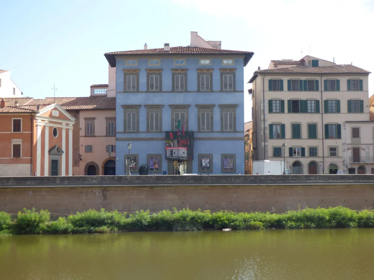 Palace and small church reflected in the green water of the river