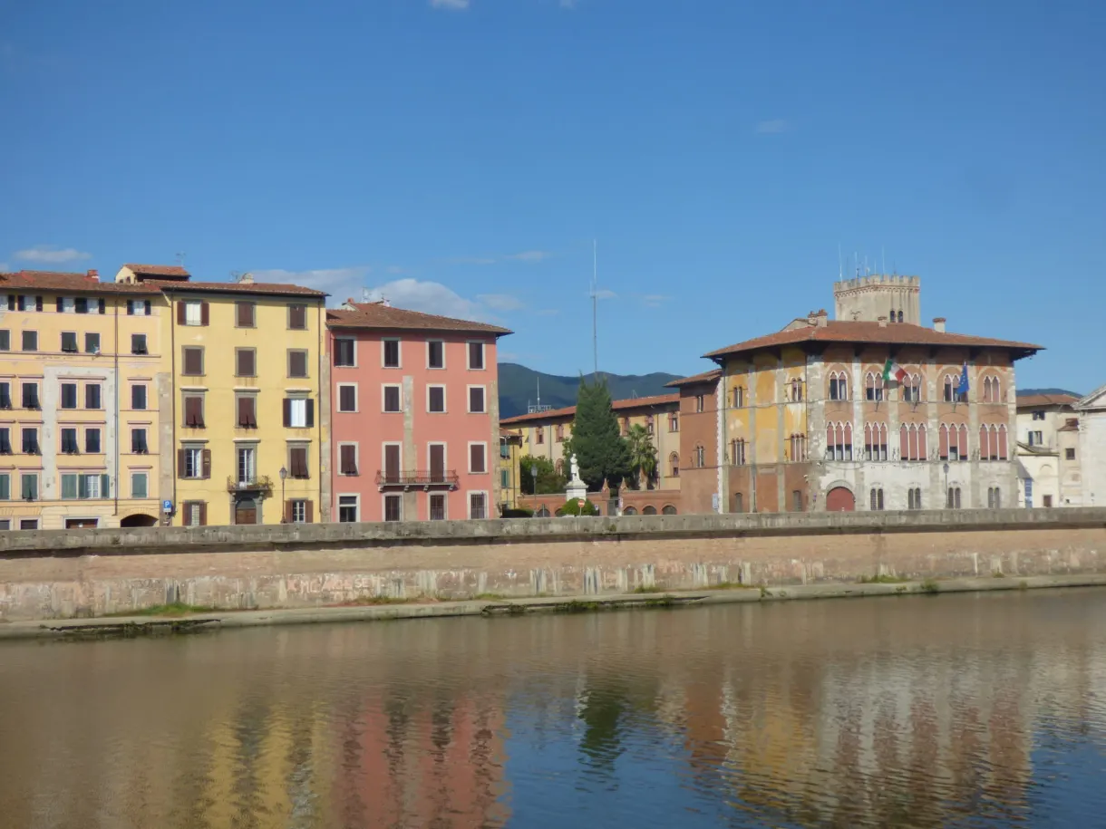 Pastel houses and crenellated tower at the river's edge