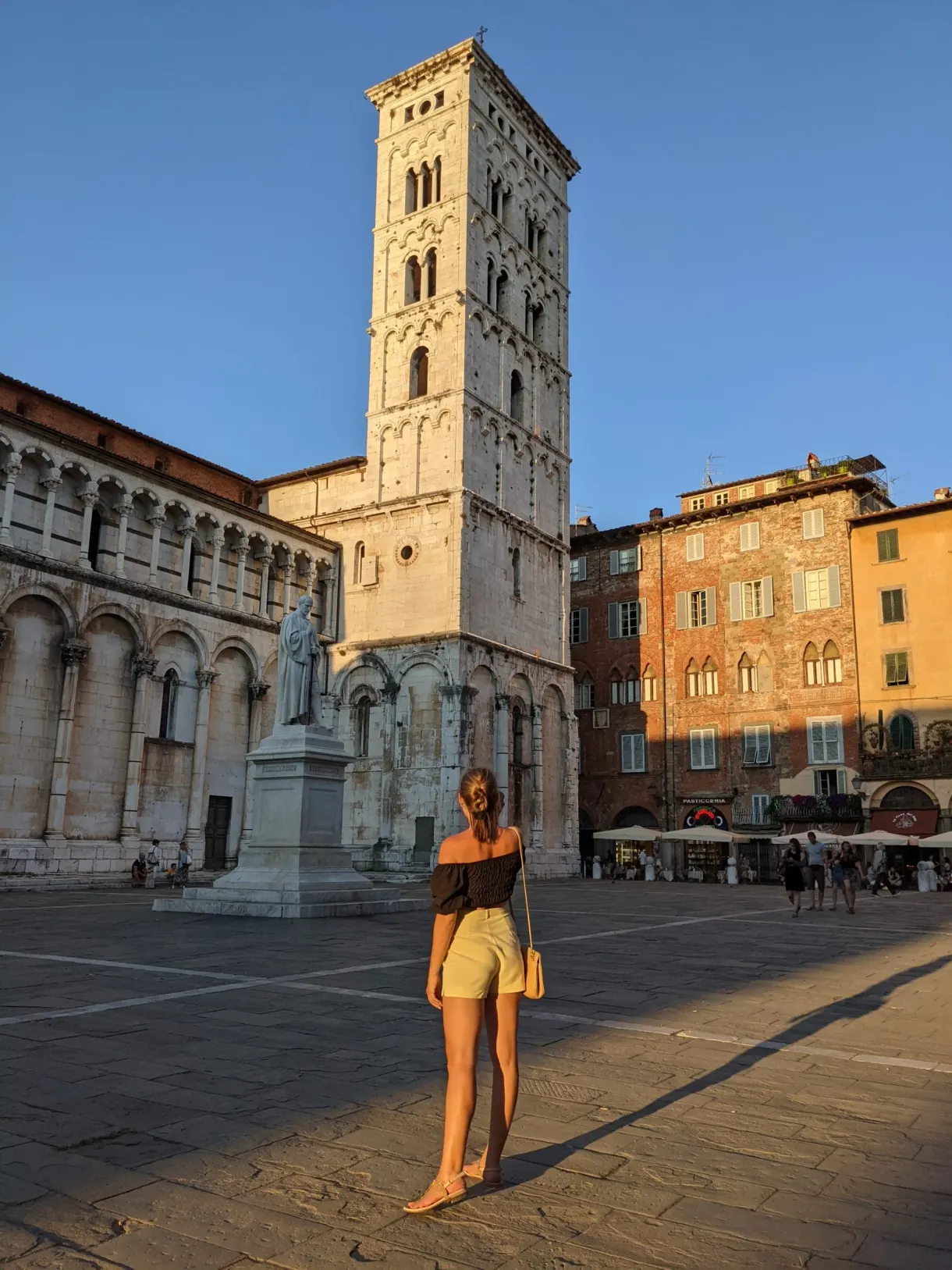 Passer by crossing the square in front of a Romanesque church