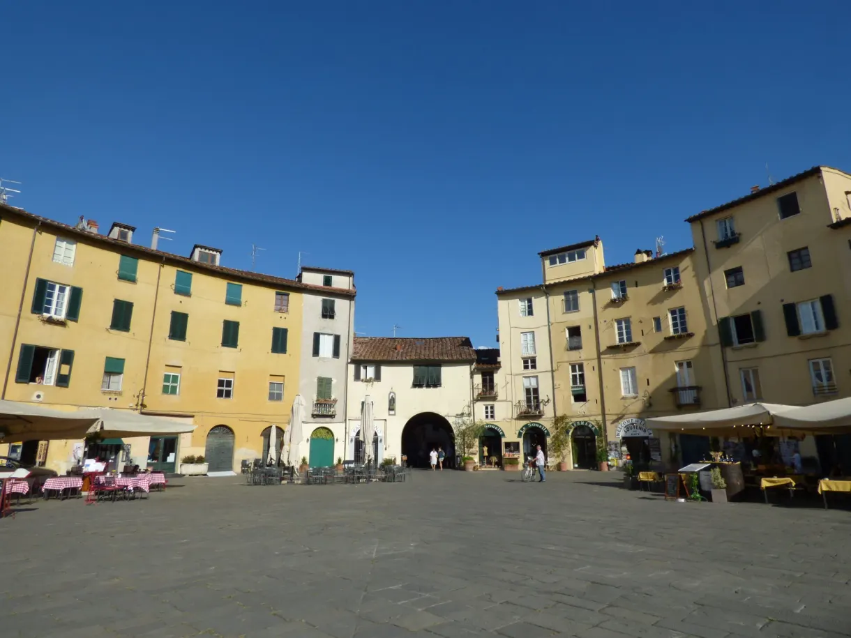 Oval square lined with yellow facades and terraces