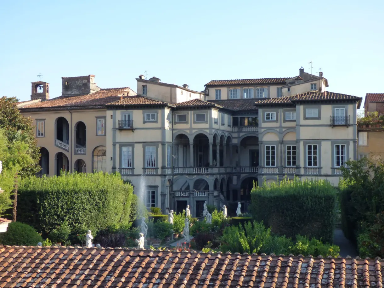 Loggia of a palace overlooking a garden and tiled roofs