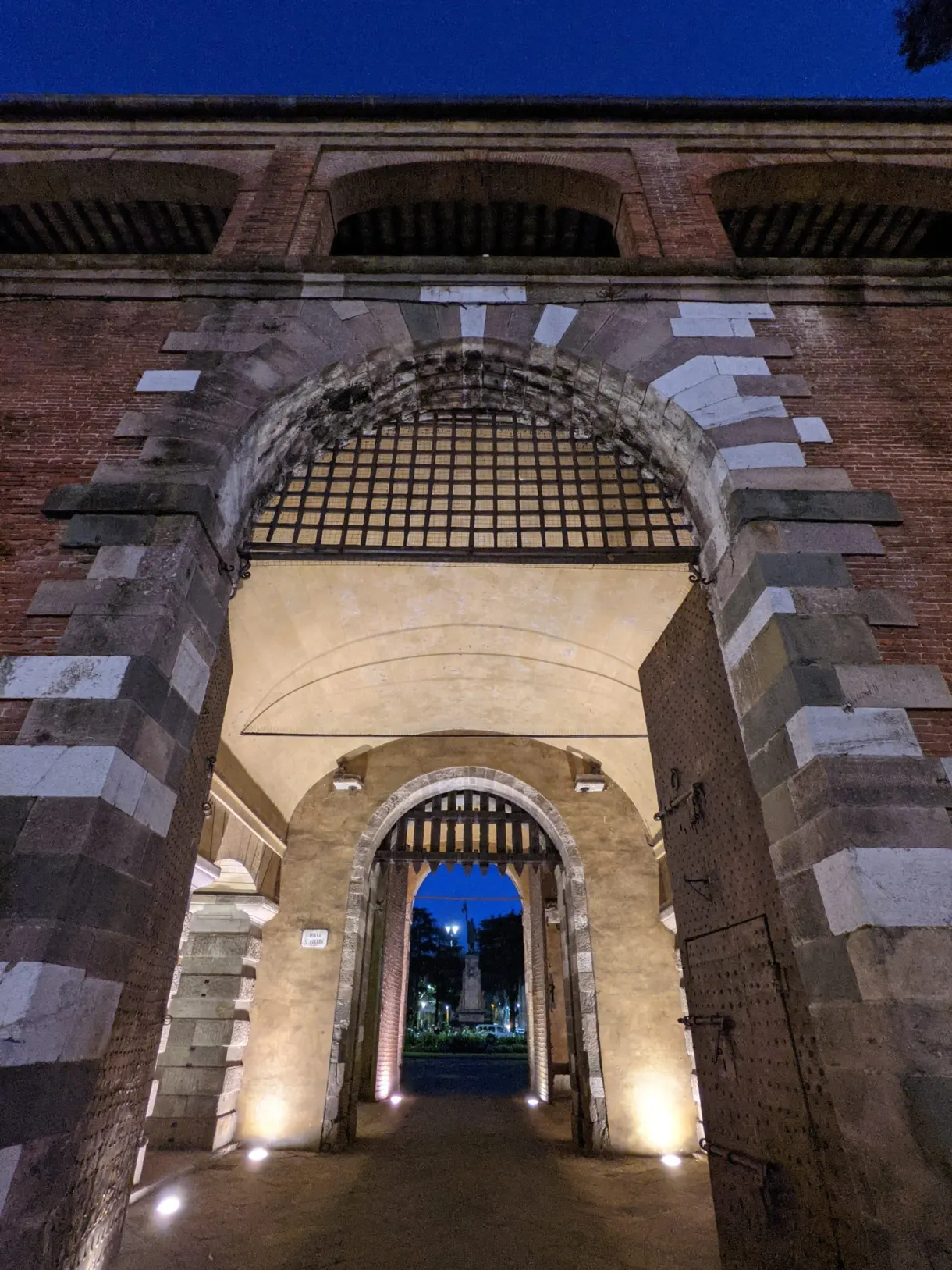 Fortified brick gate lit at nightfall