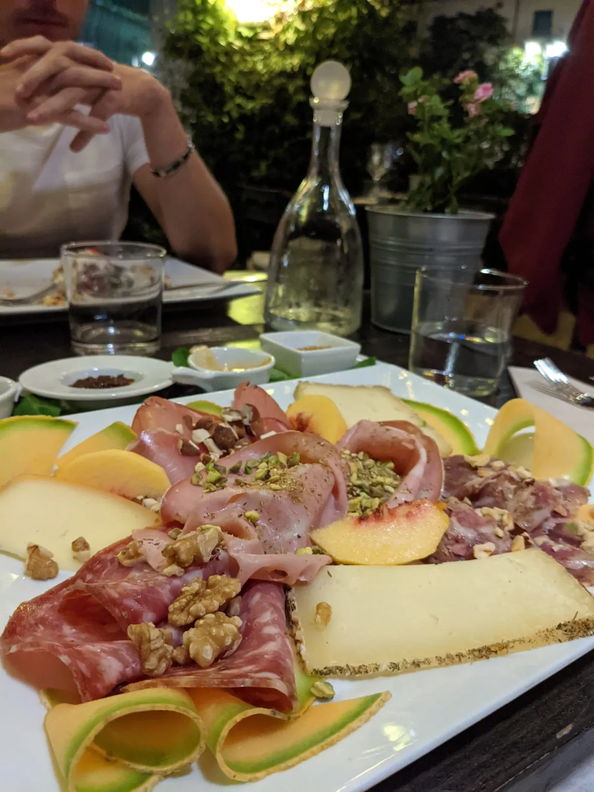 Plate of cured meats, melon and cheese shared at the table