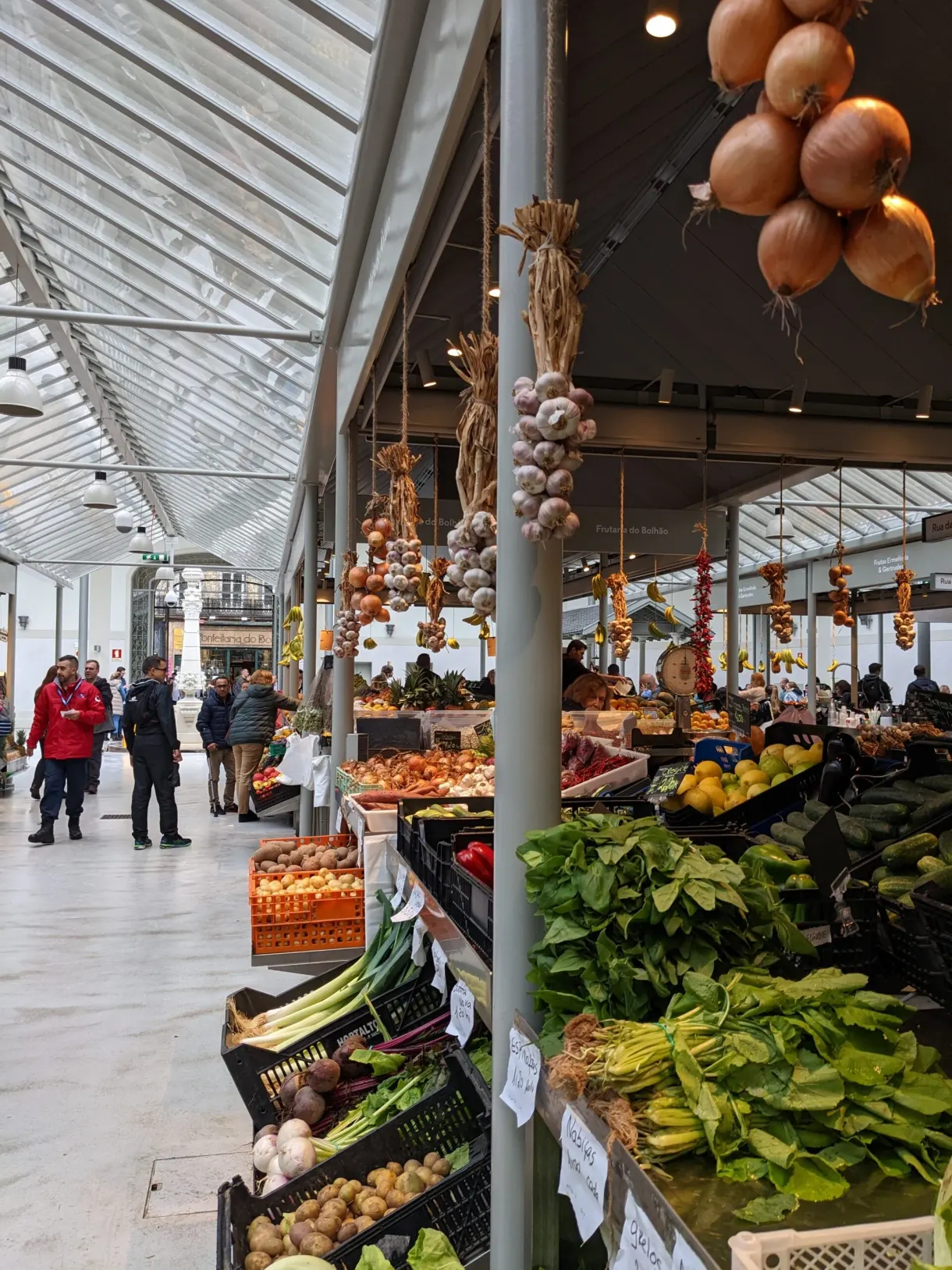 Oignons et ails suspendus au-dessus d'un étal de légumes