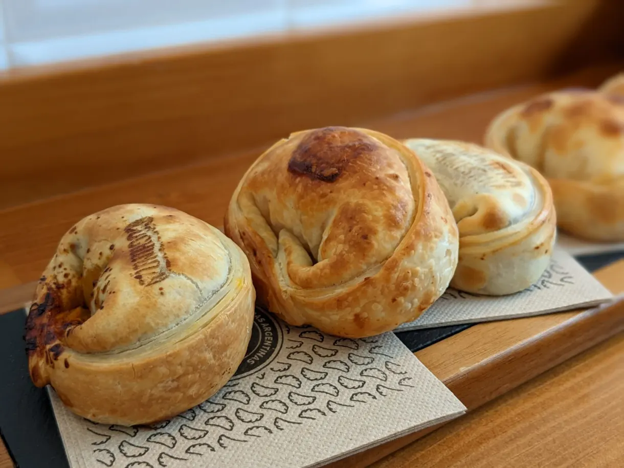 Petits pains feuilletés dorés servis sur une planche