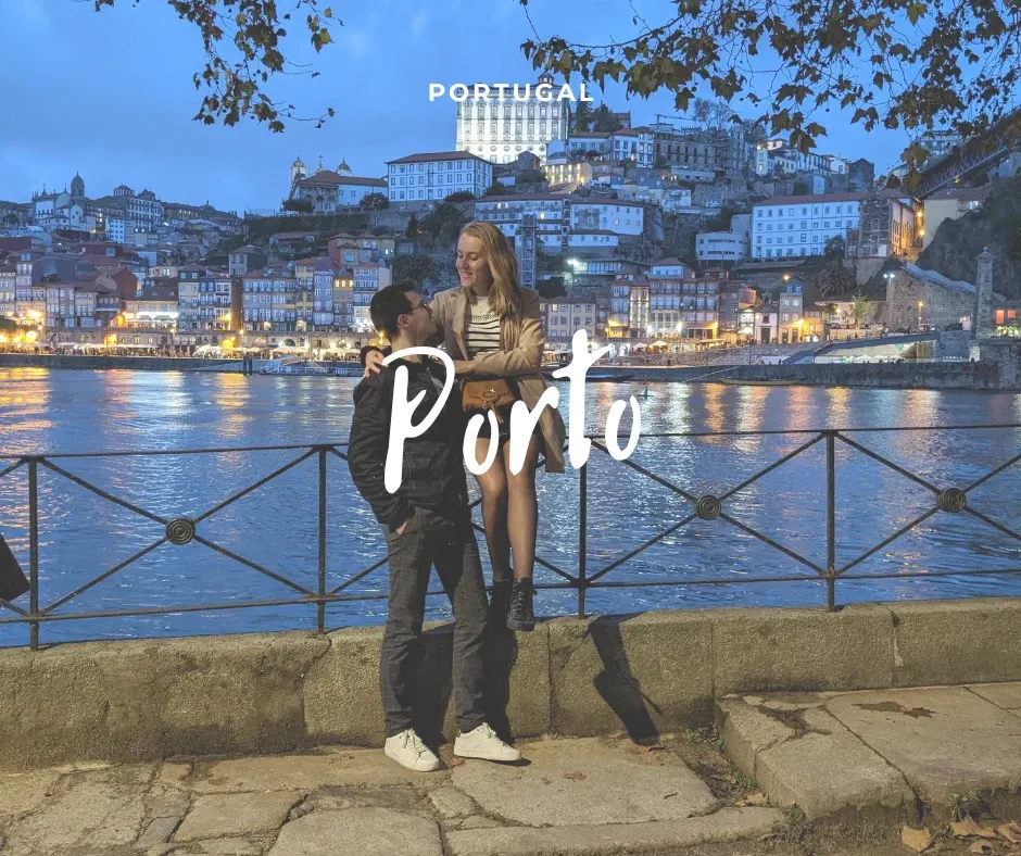 Couple sur les quais devant la ville illuminée à la nuit tombée