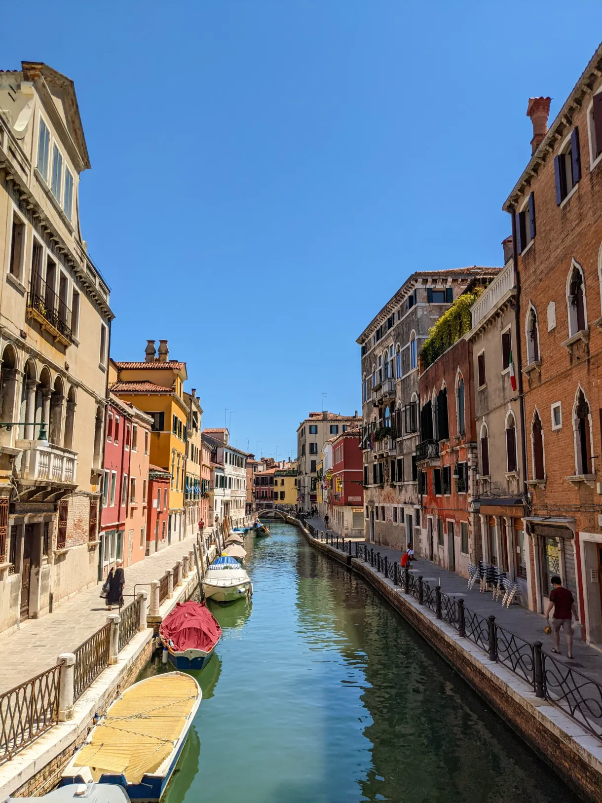 Canal étroit de Venise bordé de palais aux façades ocre