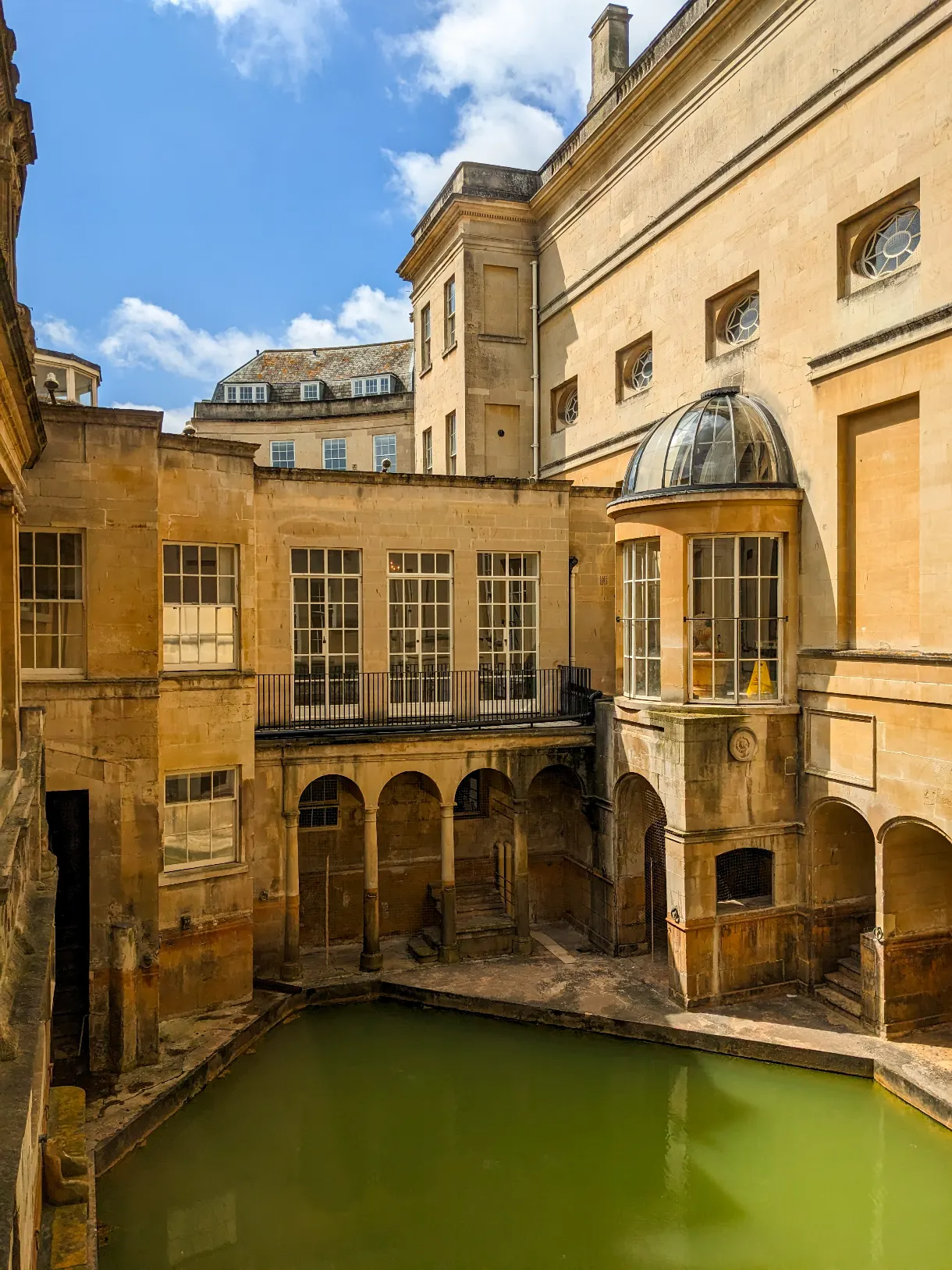Roman Baths in Bath with green water in the sunshine