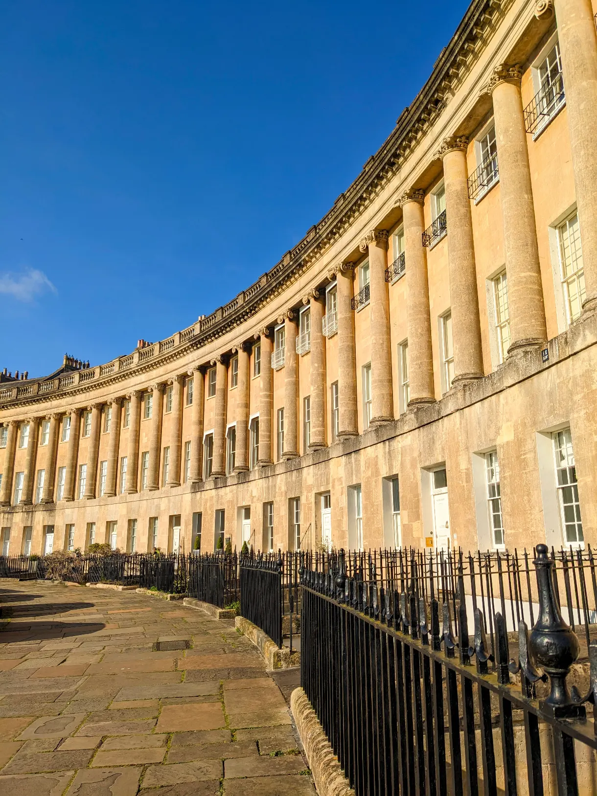 terraced townhouses lined up in a curve under the sun and blue sky