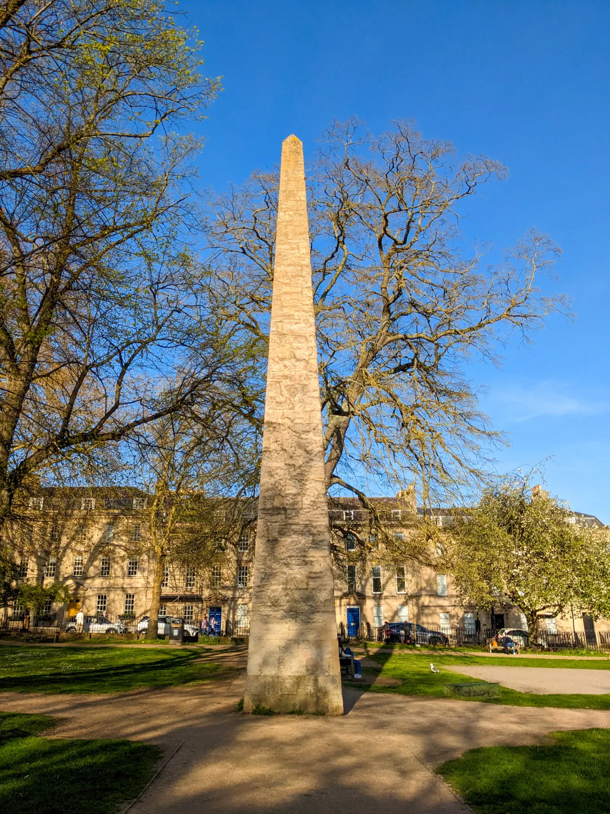 obelisk at the centre of a tree-lined square in Bath