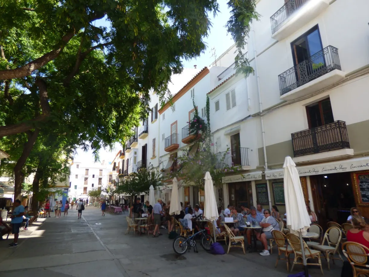 Shaded terraces and bicycles along a shopping street
