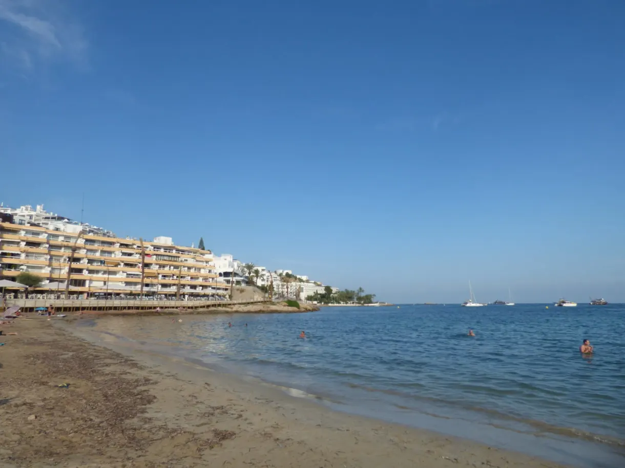 Sandy beach lined with buildings and clear water