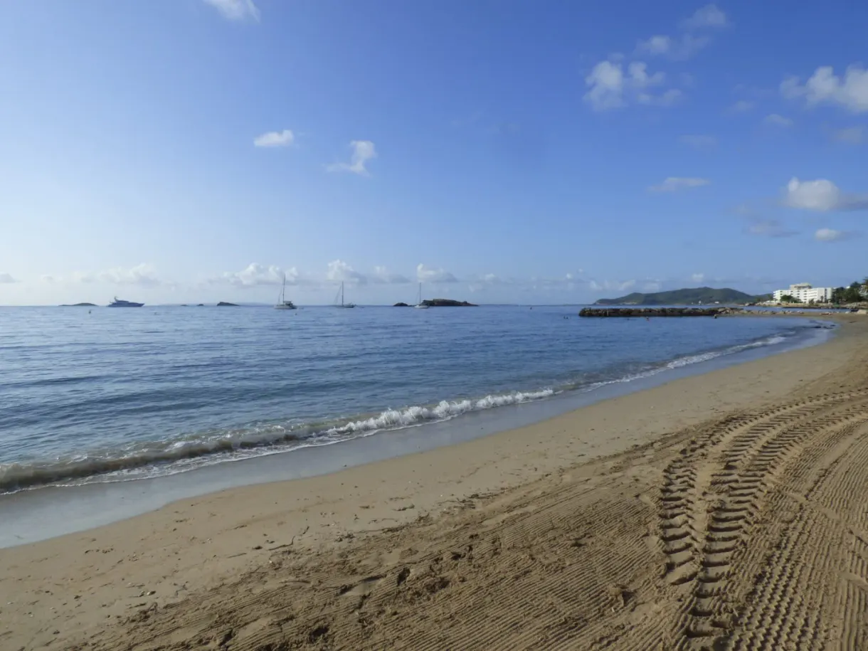 Sand raked in the early morning in front of a calm sea