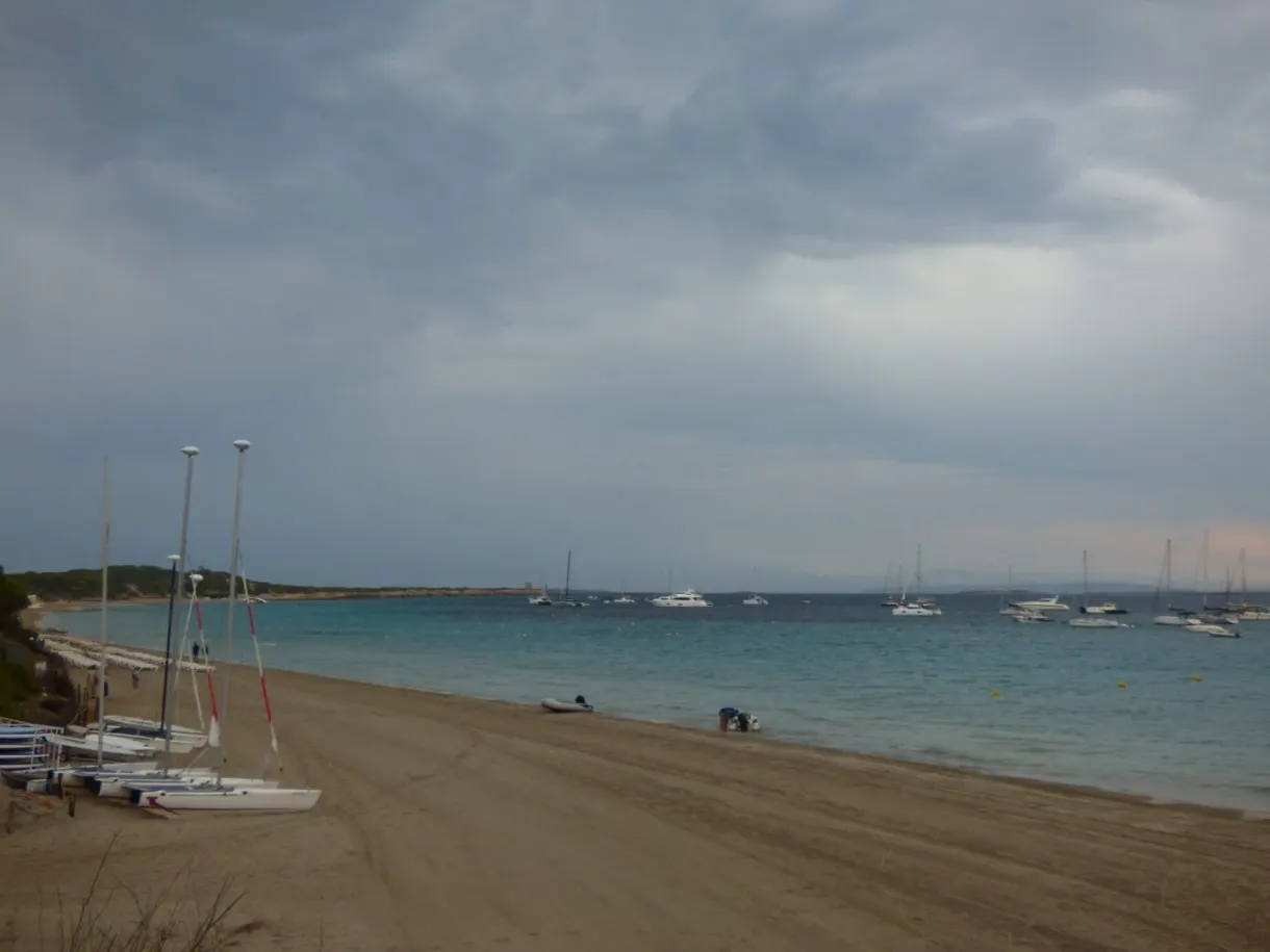 Catamarans pulled up on the sand under a heavy sky