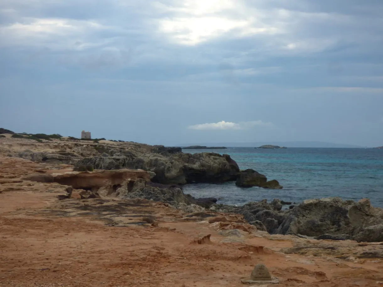 Ochre rocks plunging into a pewter coloured sea