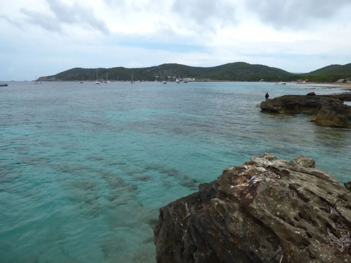 Translucent turquoise water lapping jagged rocks