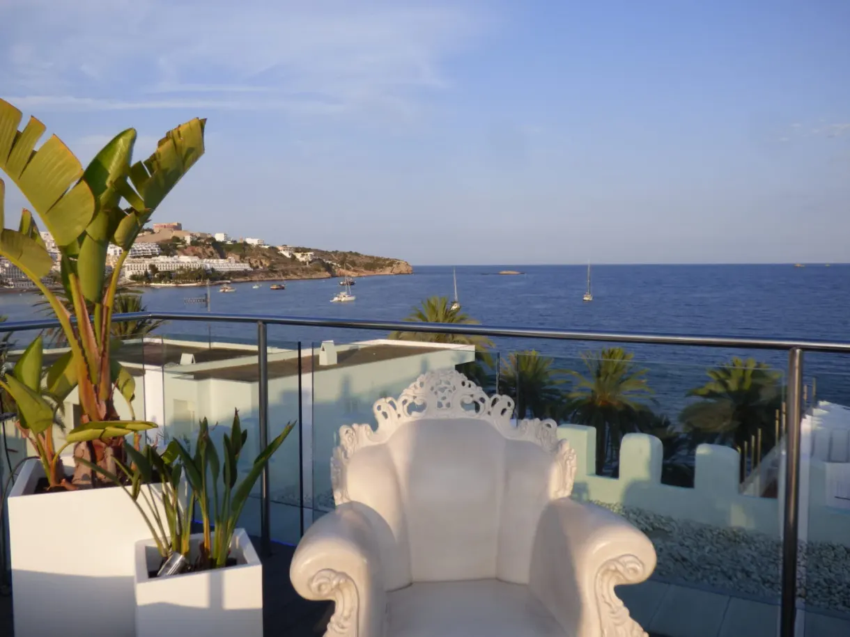 White baroque armchair on a terrace open onto the sea