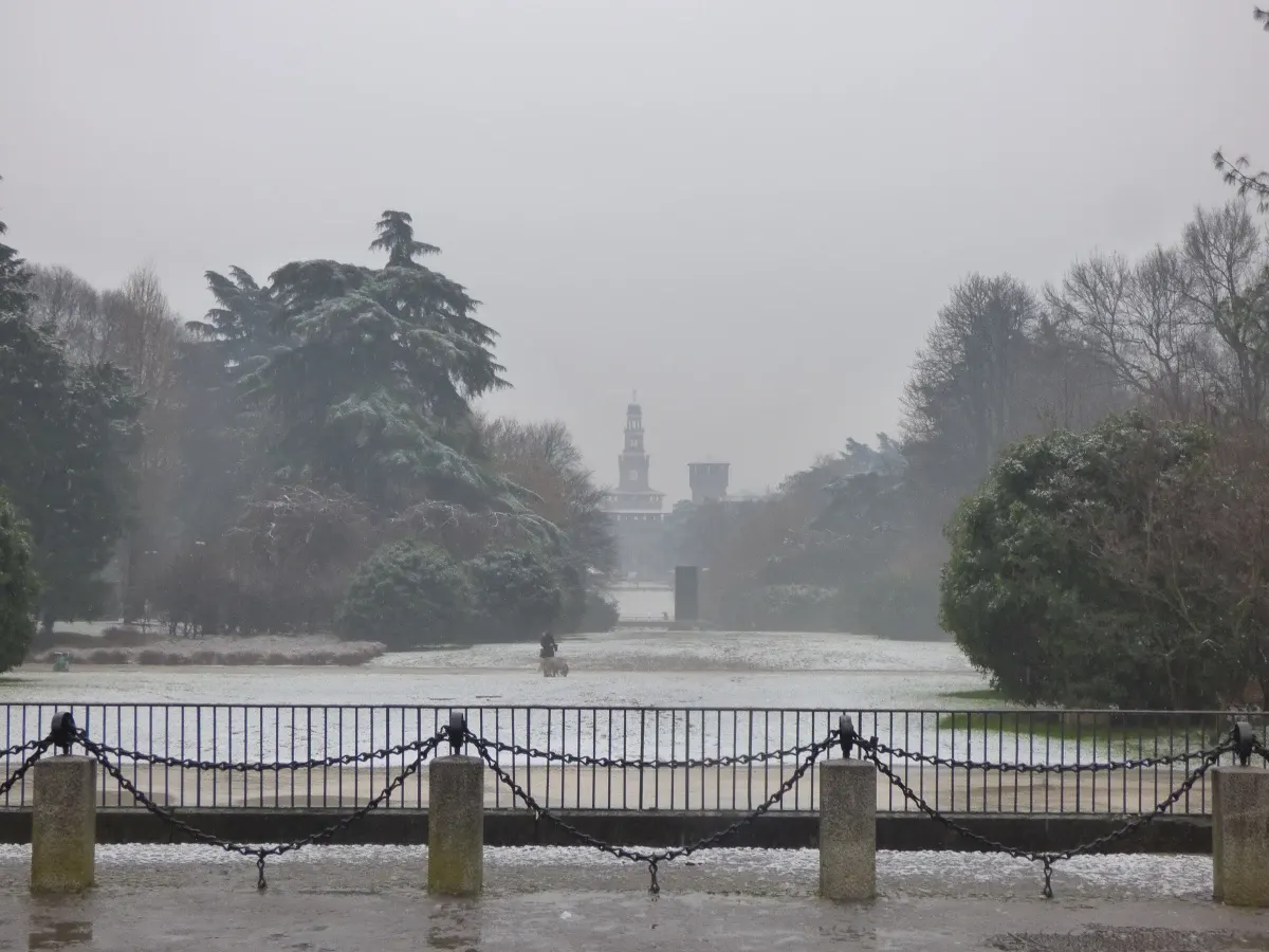 Parc enneigé et bassin gelé noyés dans la brume