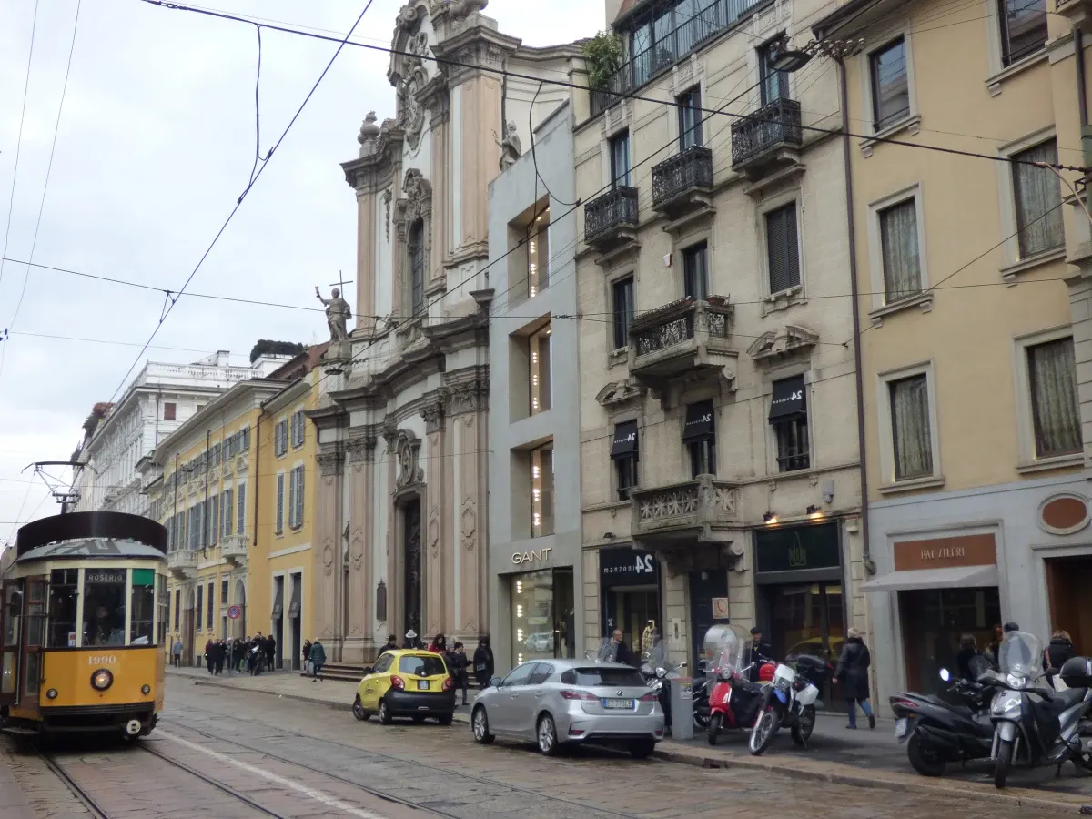 Tramway jaune descendant une rue bordée d'immeubles anciens