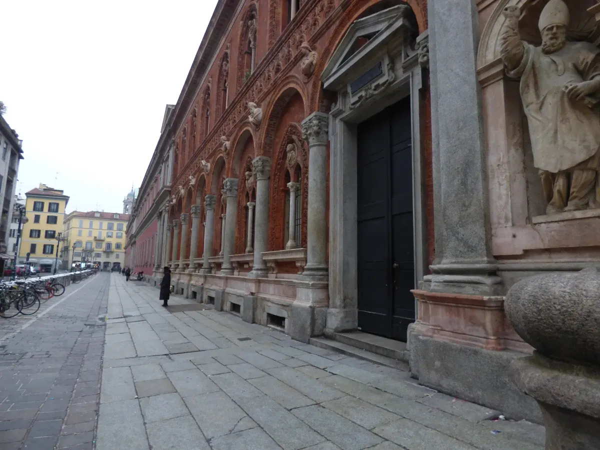 Trottoir désert longeant une façade de brique et de pierre