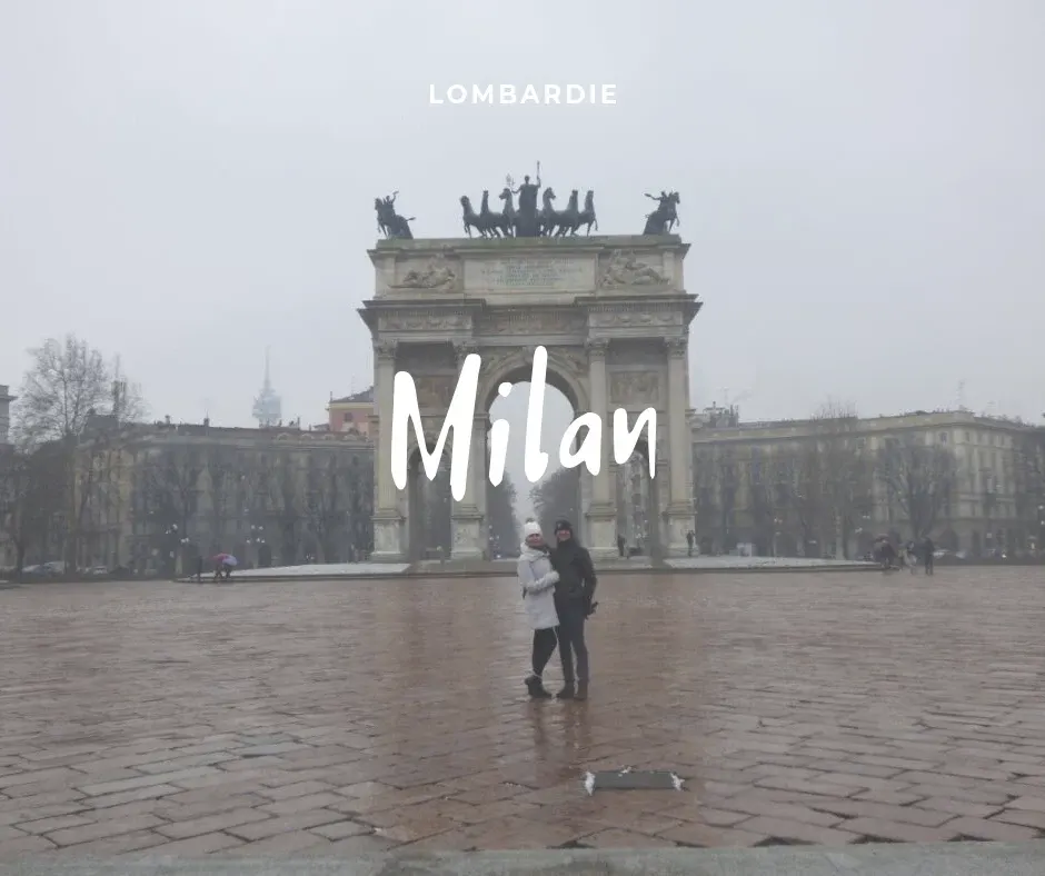 Couple enlacé devant l'Arc de la Paix sous la pluie