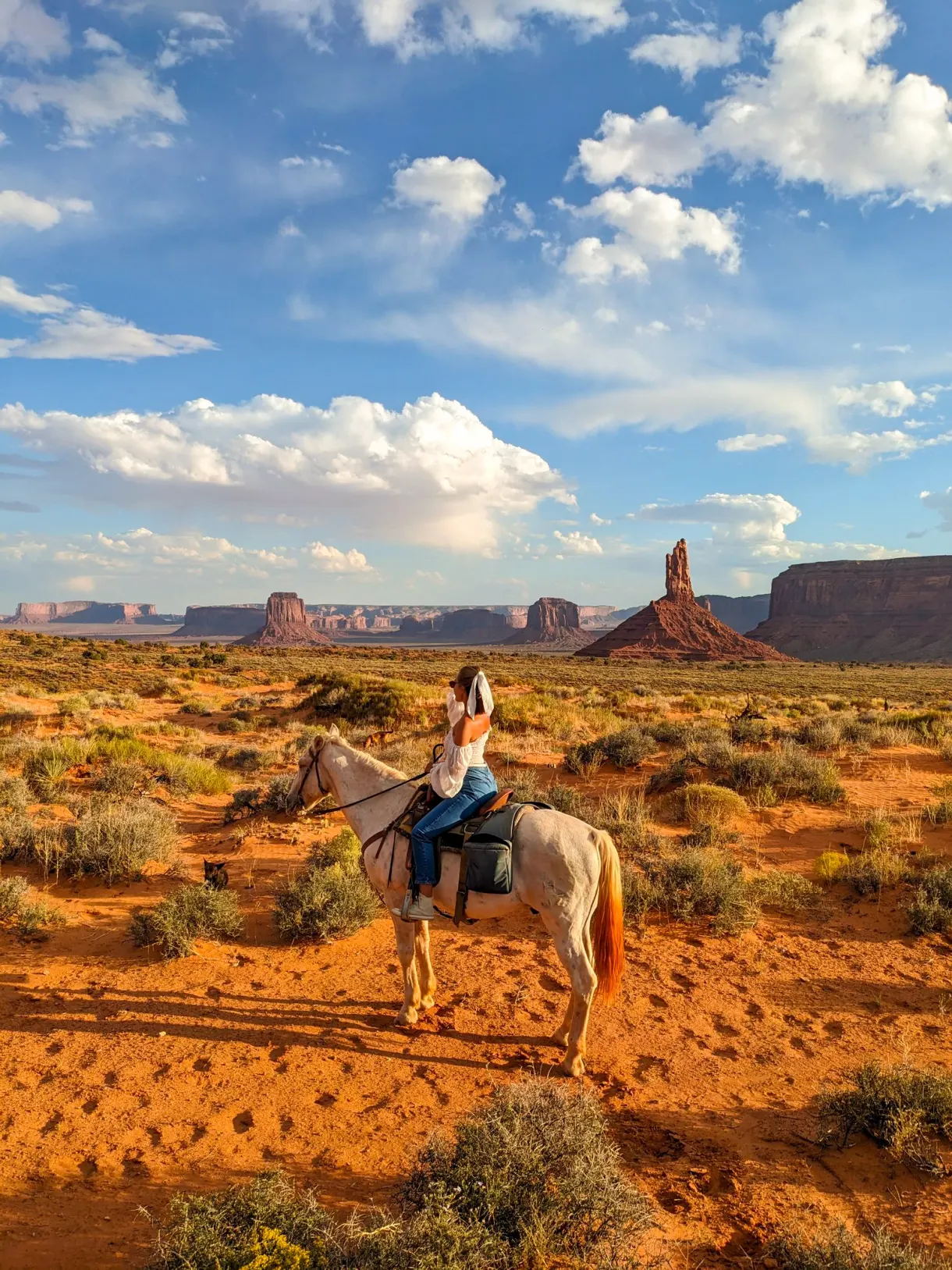 Marie on horseback facing the buttes of Monument Valley, during our road trip through the American West