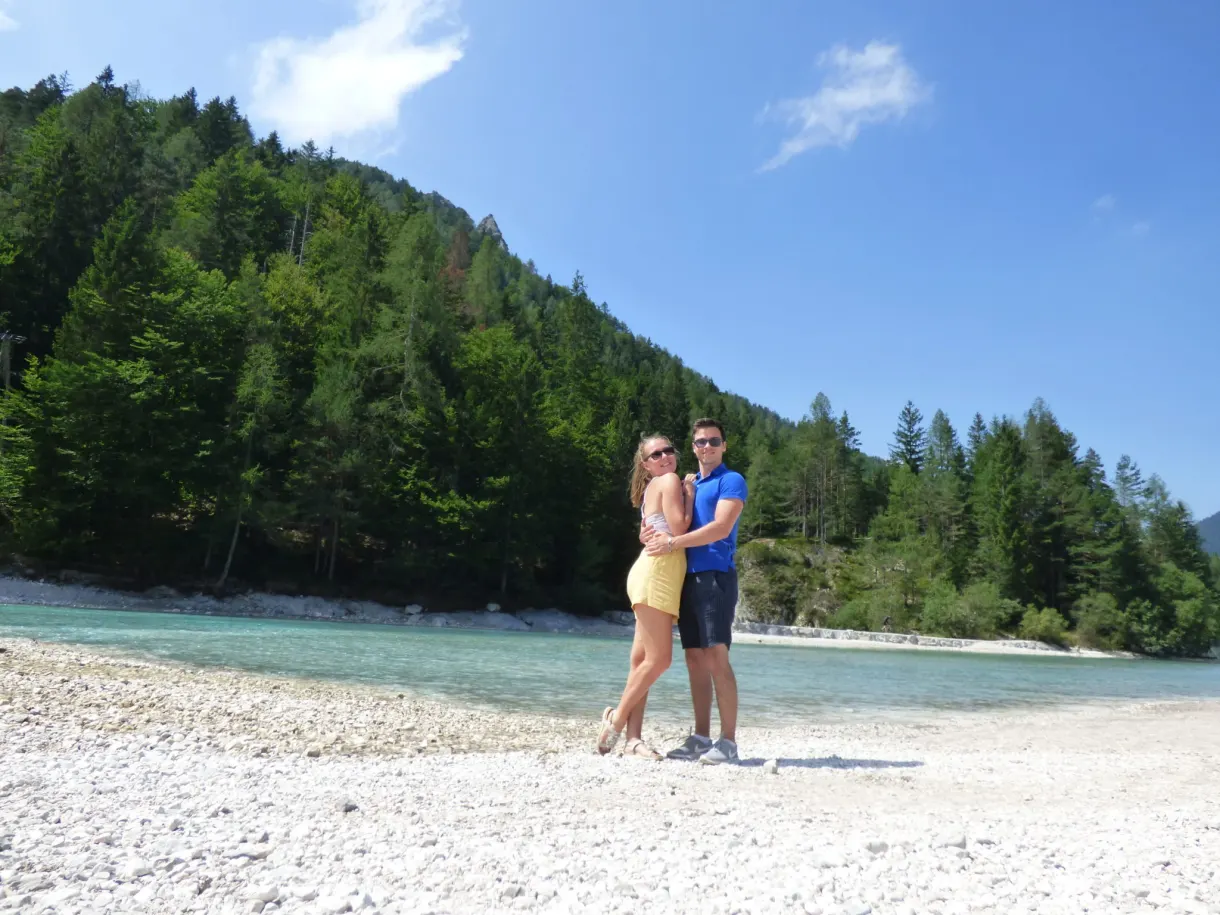 Couple posing on the pebble shore of the lake