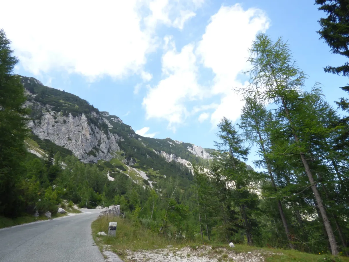 Winding road at the foot of a high limestone wall