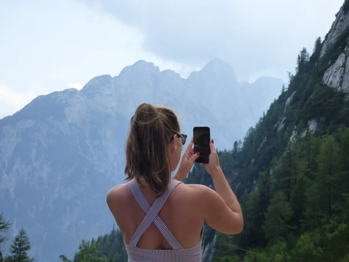 Woman photographing the summits with her phone