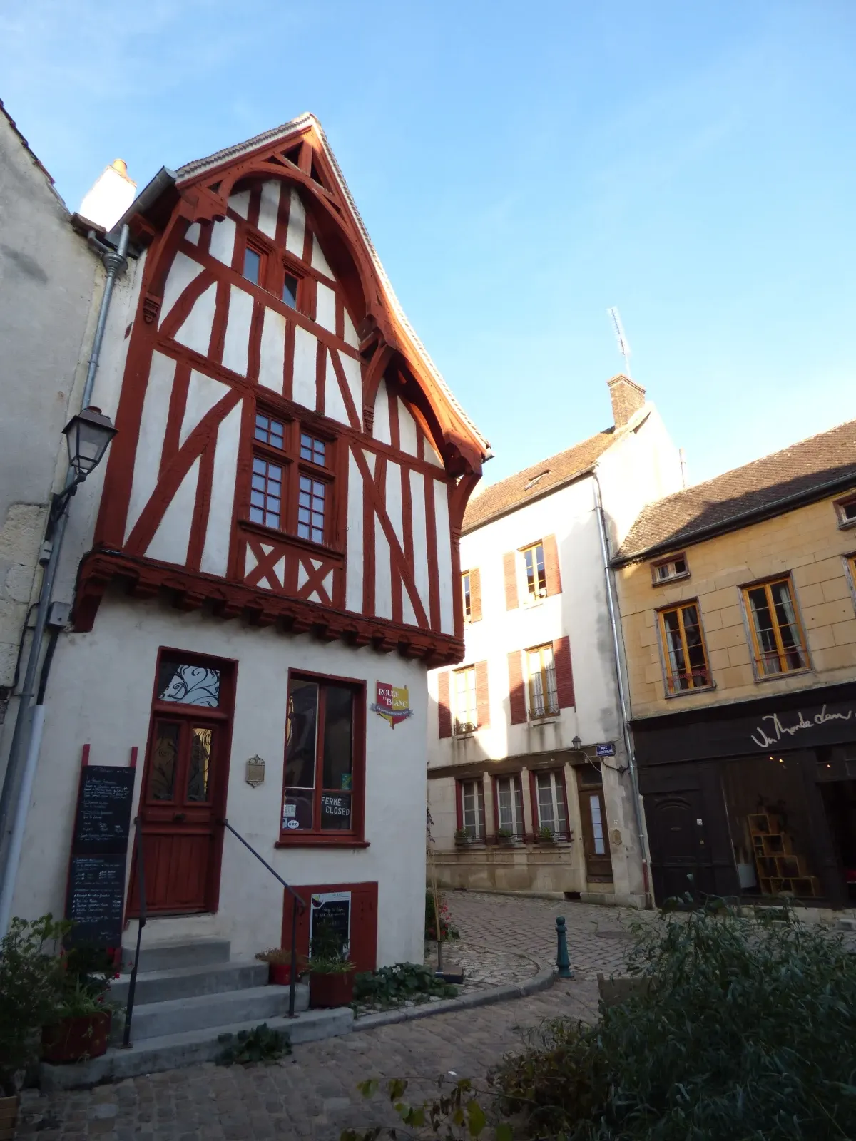Red and white half-timbered house on the corner of a square
