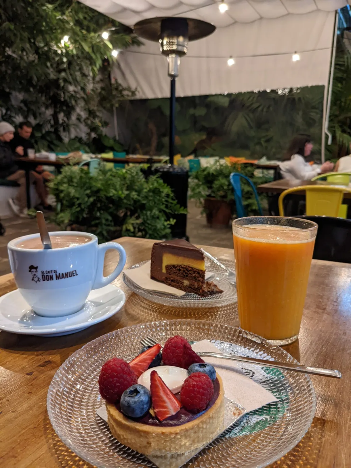 Cappuccino, jus d'orange et tartelette aux fruits rouges en terrasse