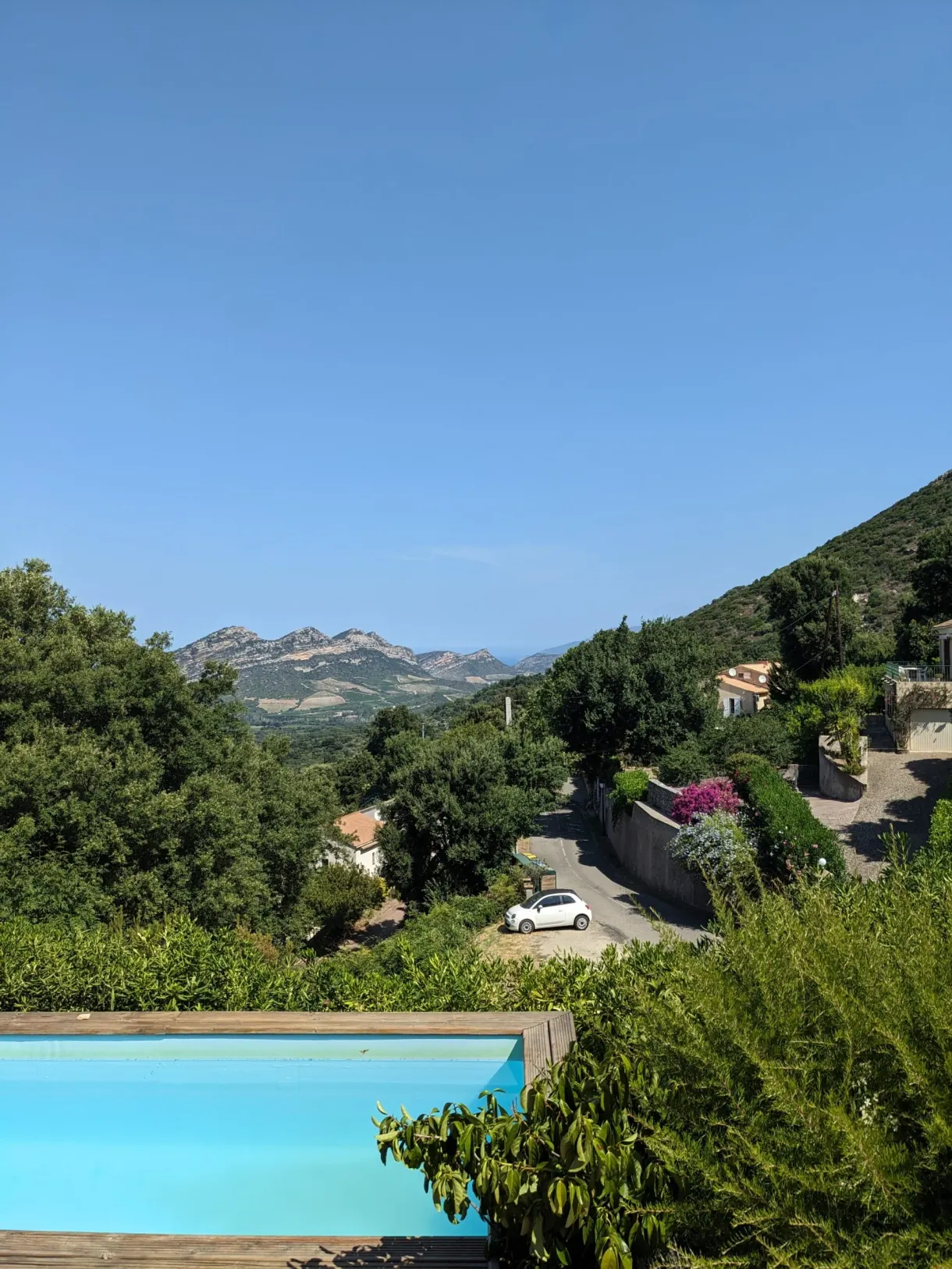 Blue swimming pool overlooking the hills of the Nebbio