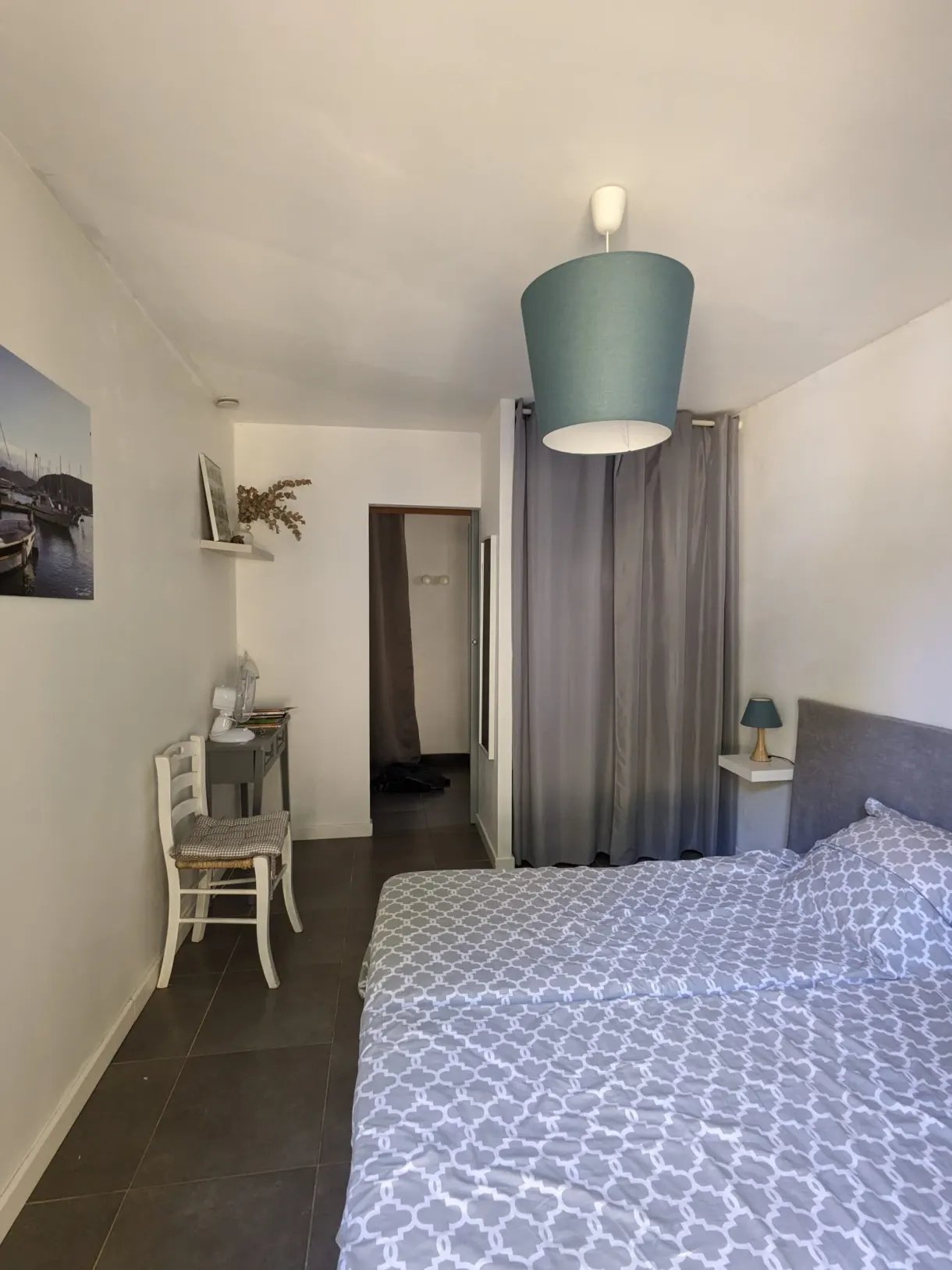 White bedroom and its pendant light above the bed