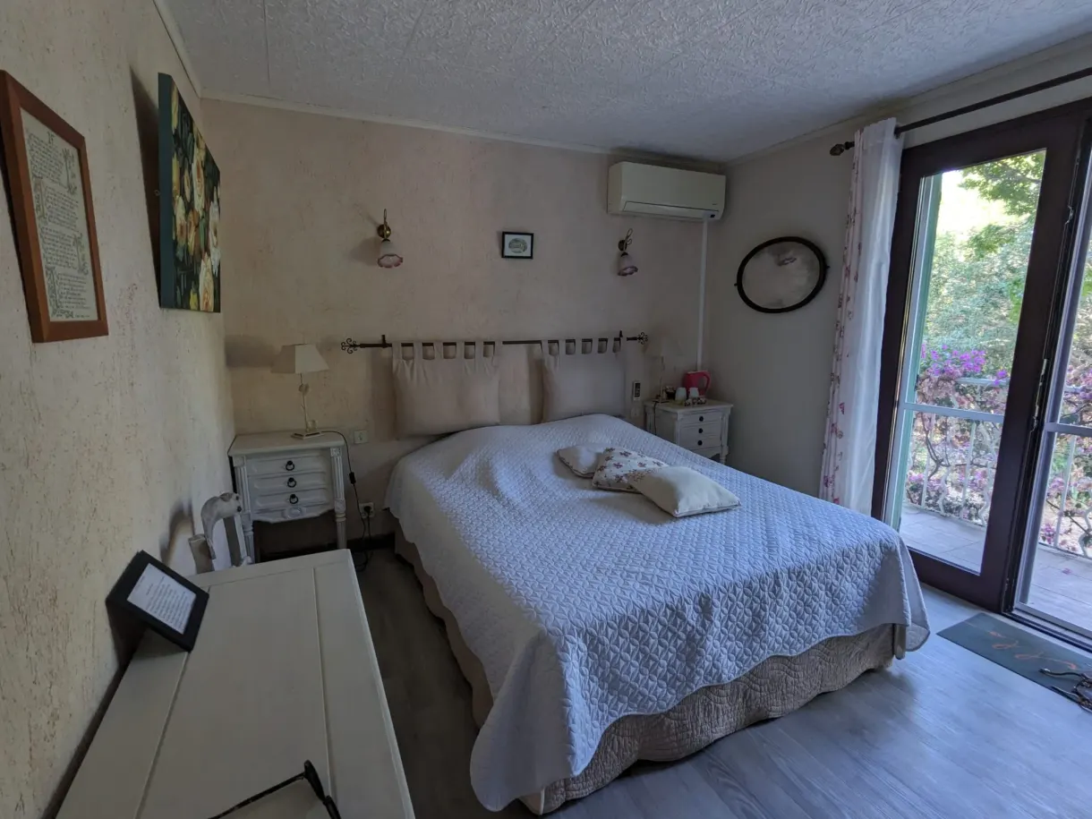 Bright bedroom opening onto the garden through a large bay window