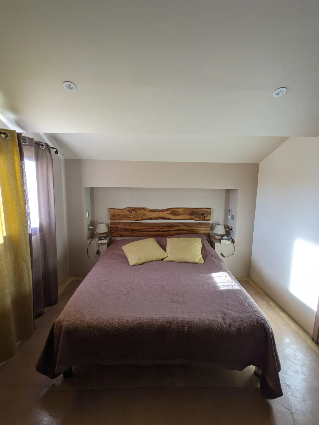 Plain bedroom and its rough wooden headboard
