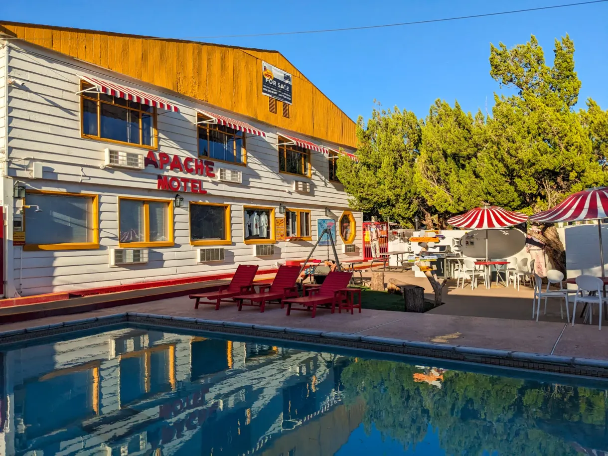Motel et sa piscine bordée de transats rouges