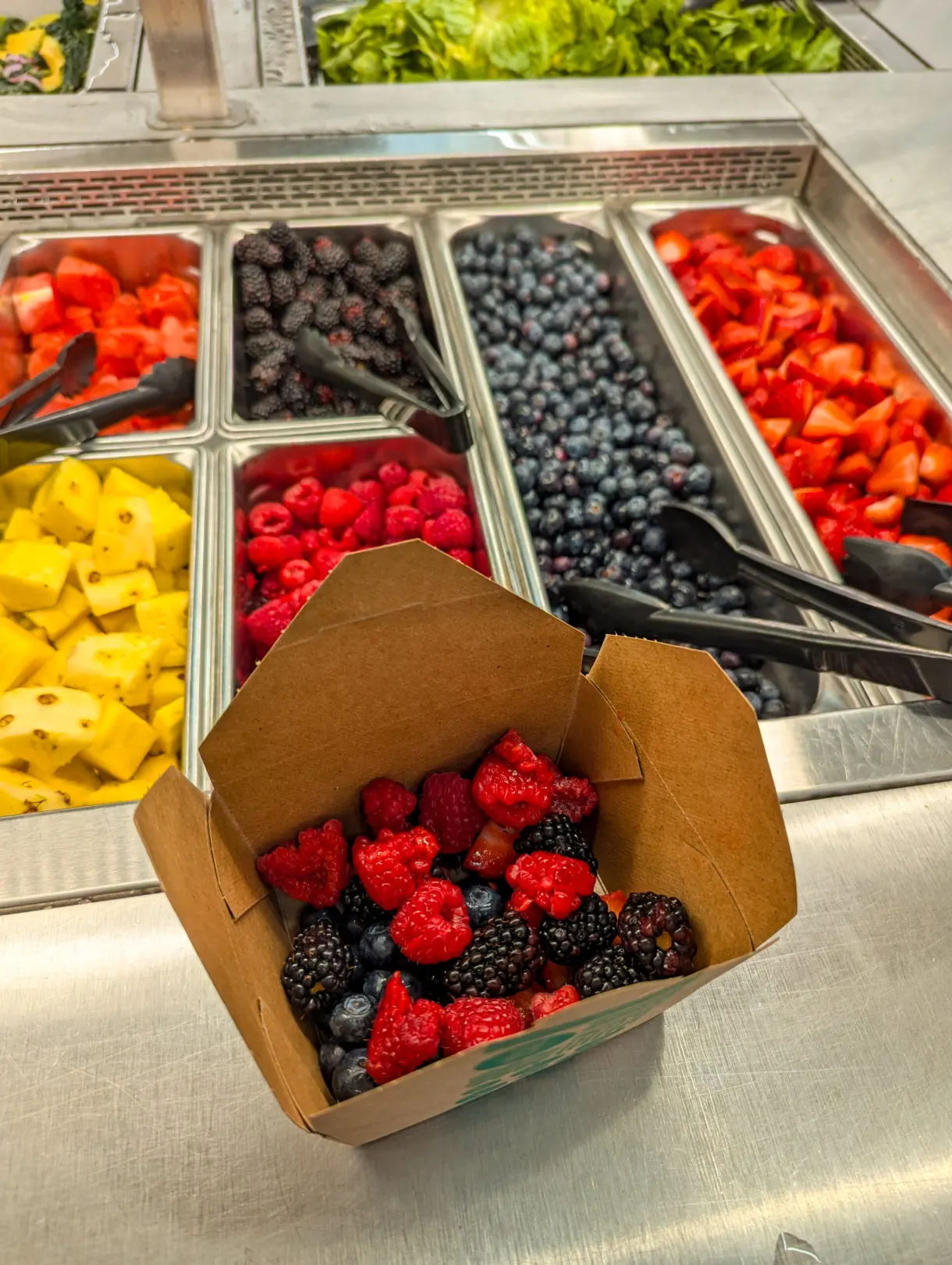Barquette remplie de fruits rouges au comptoir libre-service