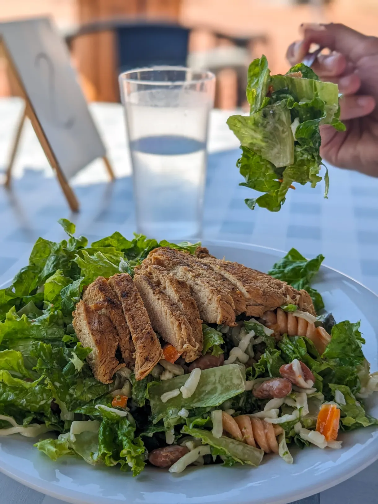 Salade verte au poulet grillé sur une table en terrasse