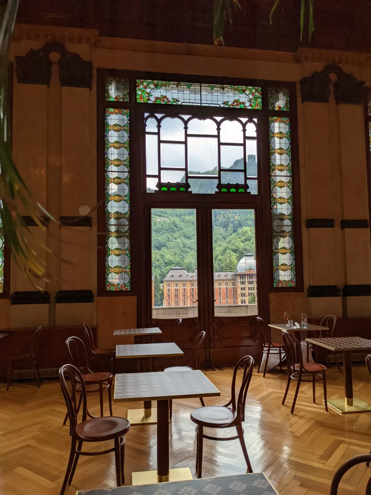 Chaises de bistrot devant des portes-fenêtres à vitraux
