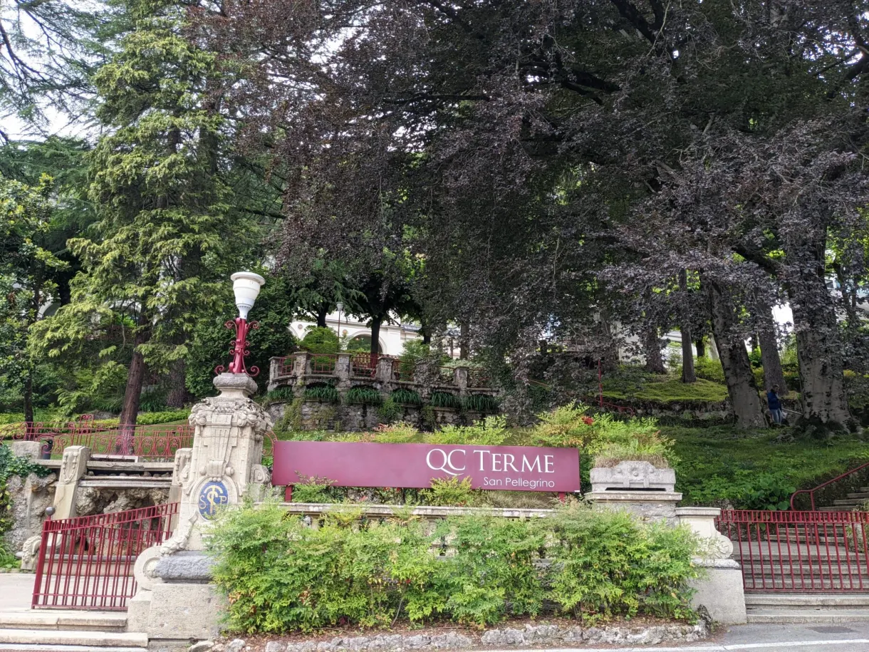 Enseigne QC Terme à l'entrée d'un parc arboré