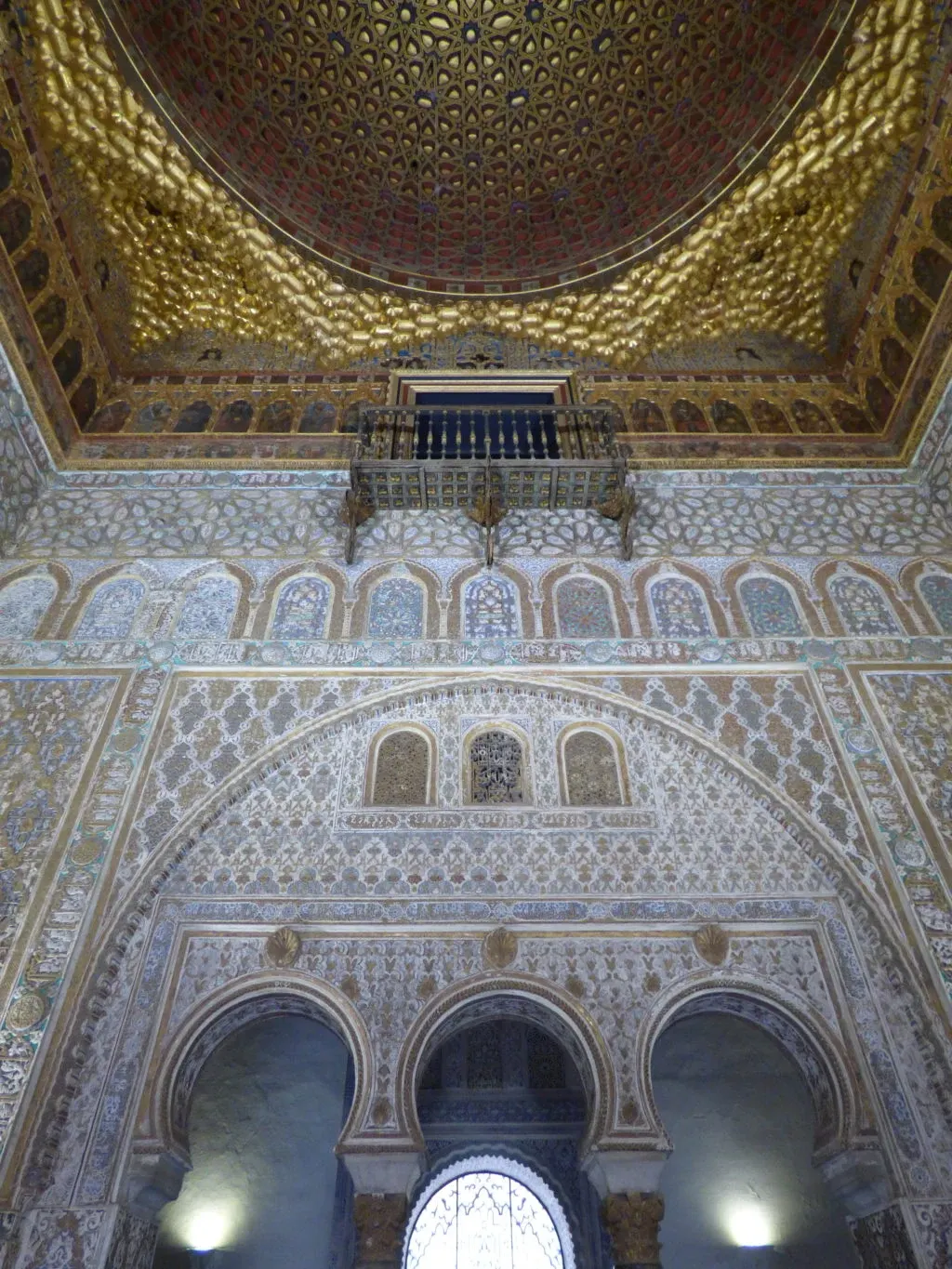 Gilded dome and chiselled stucco above the arches of the hall