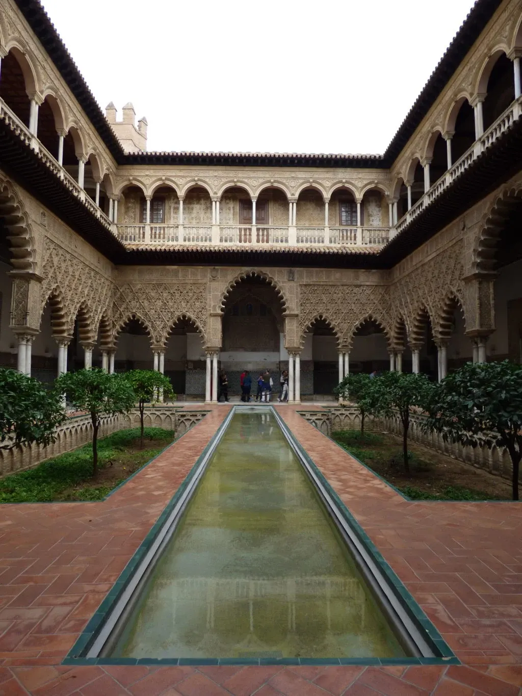 Narrow pool at the centre of the patio with its chiselled arcades