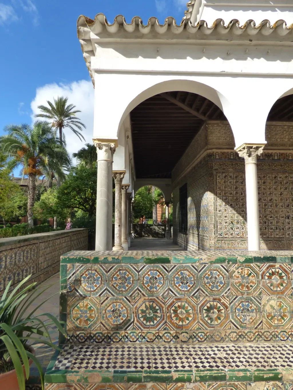 White arcaded pavilion and green ceramic bench