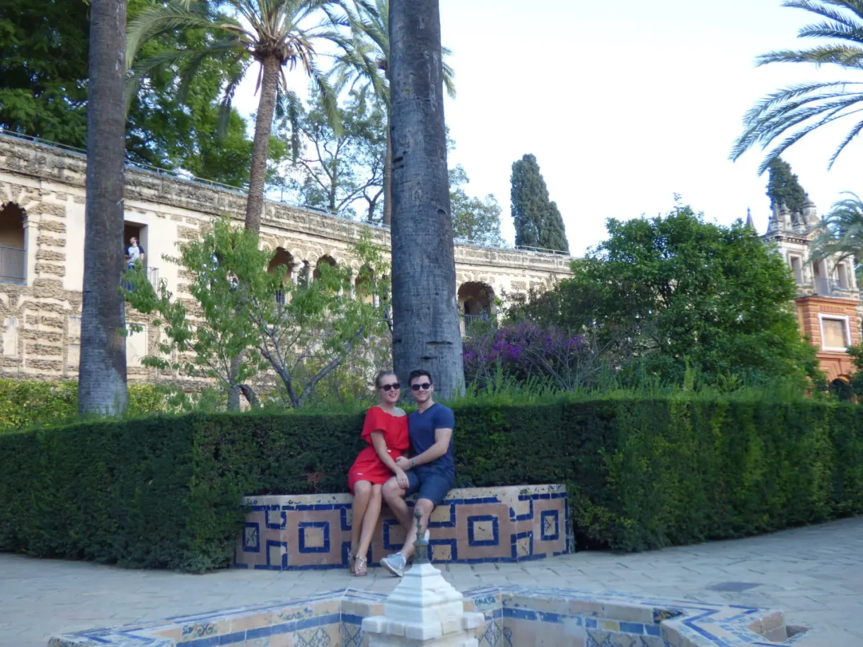 Couple sitting on a ceramic bench near a fountain