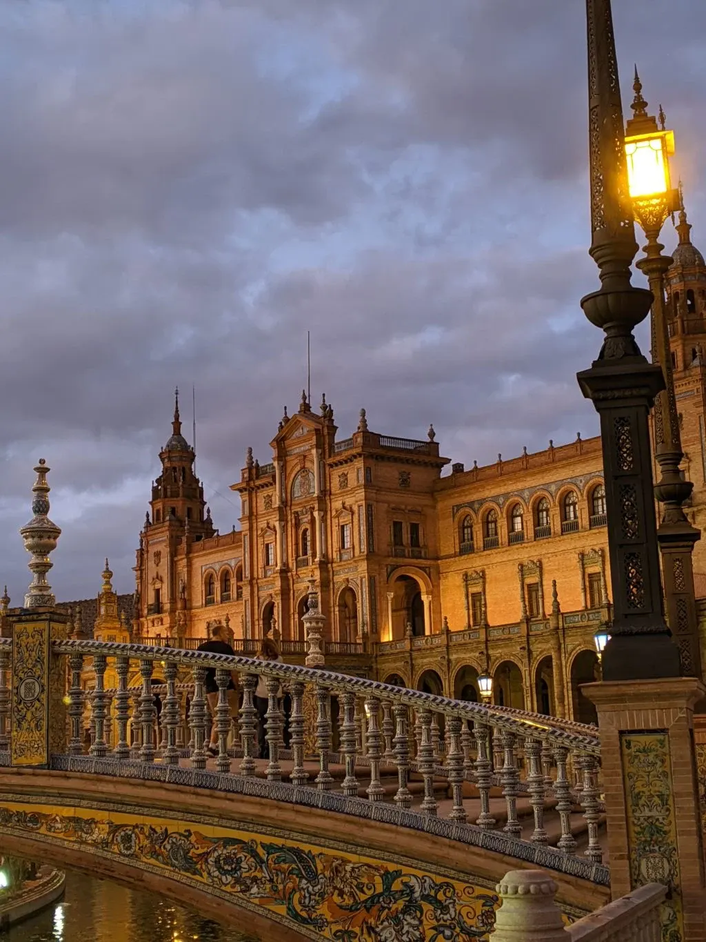 Ceramic balustrade and lit street lamp at dusk
