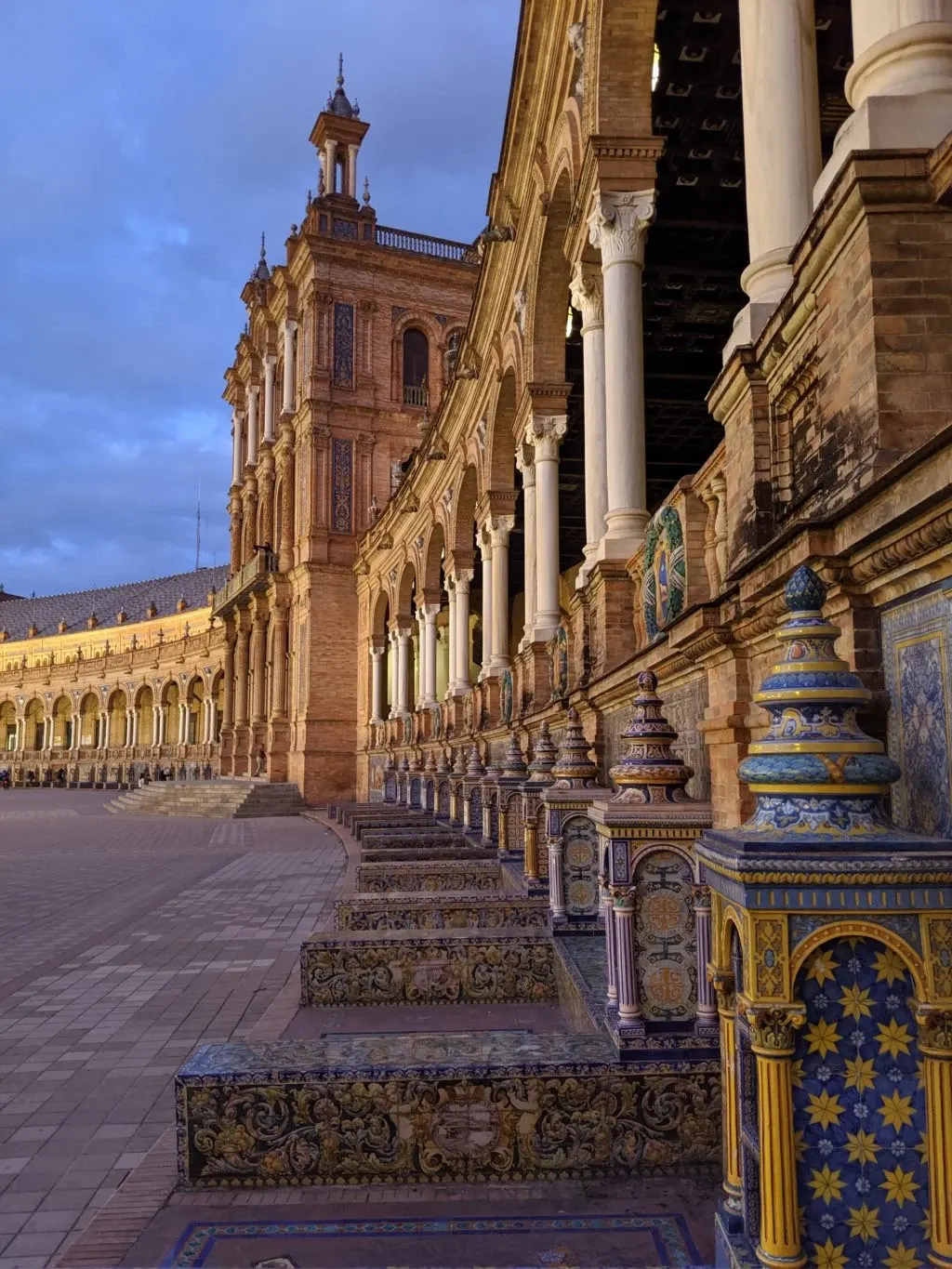 Columned gallery and earthenware benches at sunset