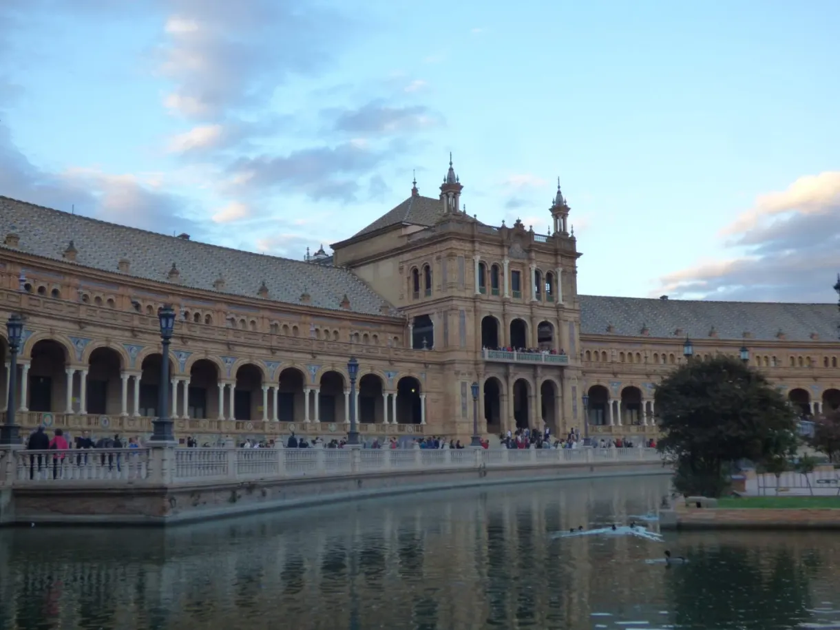 Curved wing of the palace reflected in the canal