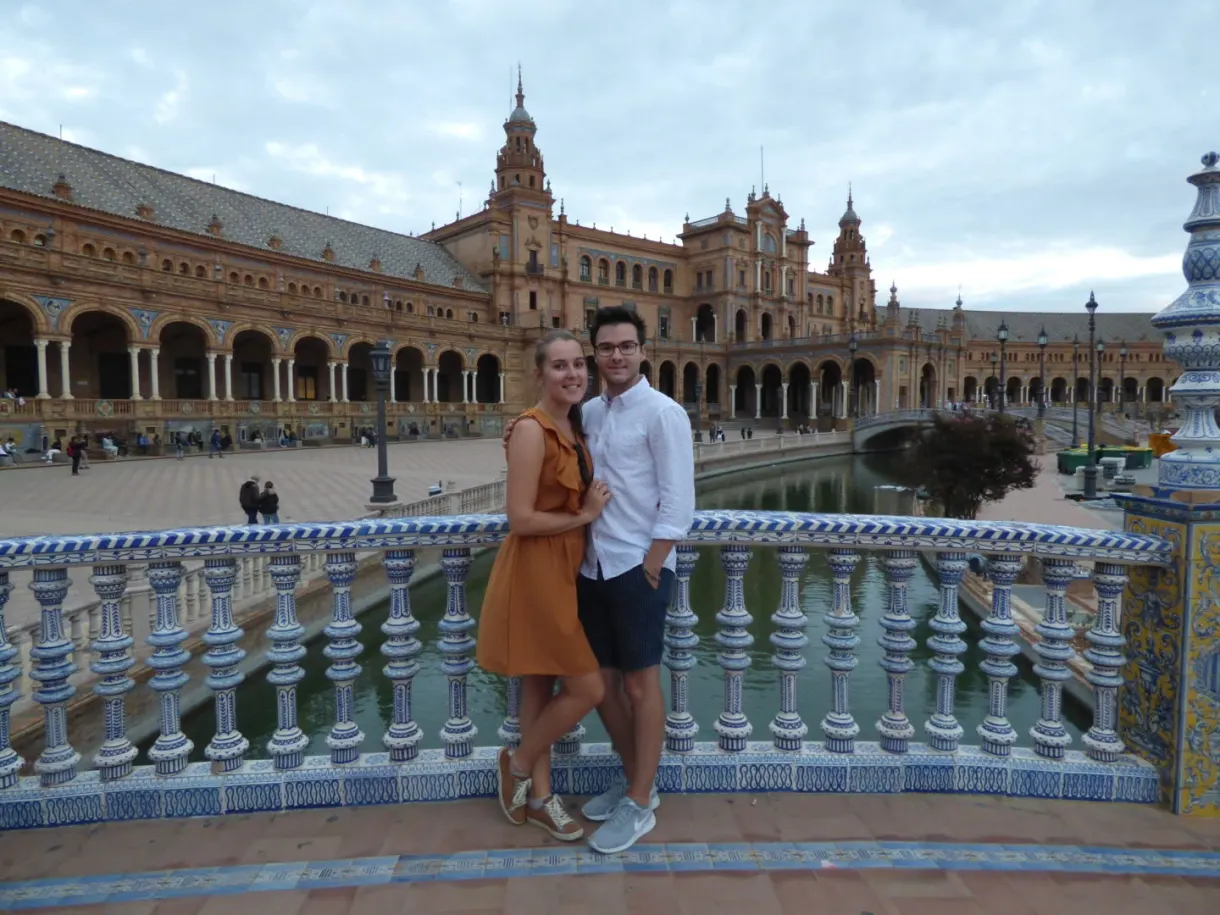 Couple embracing on the earthenware balustrade above the canal